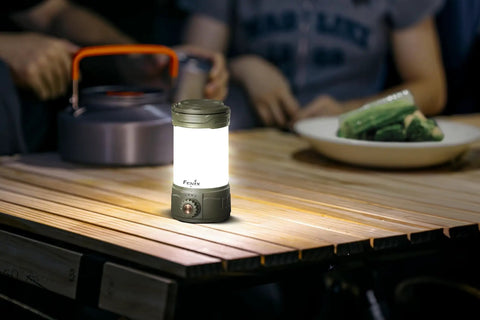 CL26R Pro Camping Lantern Olive Drab 650 Lumens USB C Rechargeable on wooden table during campsite dinner