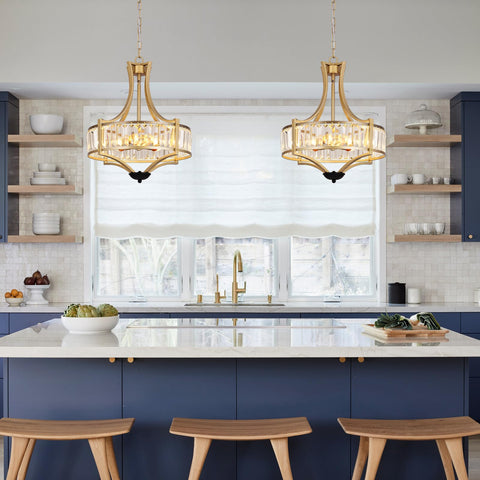 Elegant kitchen with two gold pendant lights above a marble island and blue cabinets, featuring glass shelves and natural light.