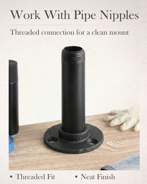 Industrial steampunk style 1/2 inch black iron pipe flange with threaded pipe nipple connection on a wooden surface.