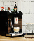 Totally Automatic Espresso Coffee Maker Featuring Responsive Touchscreen Interface with coffee cup, sleek black finish on kitchen counter.