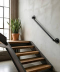 Industrial staircase with a metal railing made from Three Quarters Inch Black Malleable Iron Pipe Nipples 30 Inch Long Threaded Both Ends 10 Pack