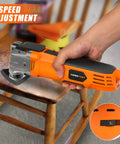 Beast Oscillating Multitool Kit 4.2 Amp with 5 Degree Oscillation, orange handle, in use on wooden furniture