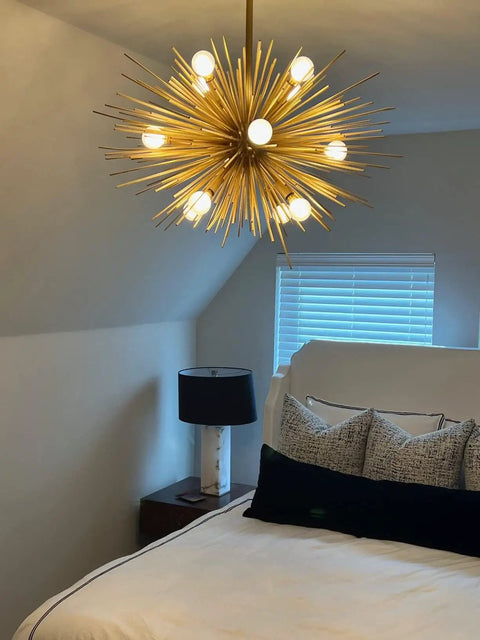 Dimmable LED Bulb E12 Candelabra, 6W 60W Equivalent in a modern gold spiky chandelier above a bed with pillows, soft white 3000K lighting