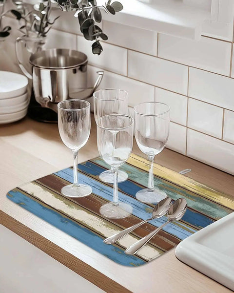 Blue Yellow Brown Wood Grain Dish Drying Mat For Kitchen Counter Absorbent Microfiber Quick Drying Machine Washable 16 By 18 Inches Abstract Art For Countertop with wine glasses and cutlery on top.