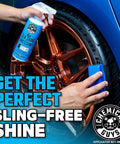 Person applying Silk Shine Dressing to a car's copper-colored rim with blue applicator, achieving a sling-free shine.