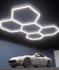 Hexagon LED Garage Light 5-HEX 240W 5000K Daylight installed in a garage ceiling, illuminating a car below.