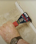 Using Lightweight Trim Puller Mini Multi Tool For Tight Spaces to remove baseboard trim in a compact interior space.
