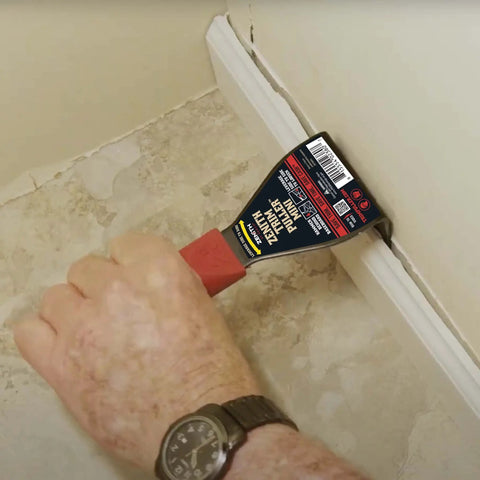 Using Lightweight Trim Puller Mini Multi Tool For Tight Spaces to remove baseboard trim in a compact interior space.