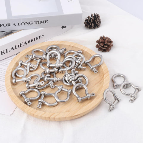 25 Pack One Quarter Inch 304 Stainless Steel D Ring Shackles Set on wooden platter for outdoor adventure and recovery