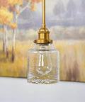 Set Of Three Hammered Cylinder Glass Shade Pendant Lights For Bathroom Vanity And Chandelier Upgrade In Modern Water Glass Design 6 Inch By 5 Inch Shades That Fit Threaded Medium Base Sockets Perfect For Any Home hanging shown in modern setting