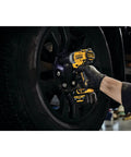 12V Max 3/8 Inch Cordless Impact Wrench Kit in use, removing tire bolts from a vehicle wheel, ergonomic design for easy handling.