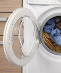 Front-loading washing machine with the door open and blue and brown laundry inside.