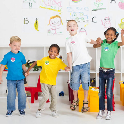 Children wearing Hello My Name Is Round Name Tag Stickers Set 315 Pcs In 9 Macaron Colors for classroom organization.