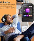 Man relaxing with headphones alongside Bluetooth 5.3 Portable Music Player With Built In Speaker And Micro SD Slot Up To 512GB FM Radio Video Playback Voice Recording Earphones Included Kid Friendly Gift For Kids On The Go Jogging Or Travel.