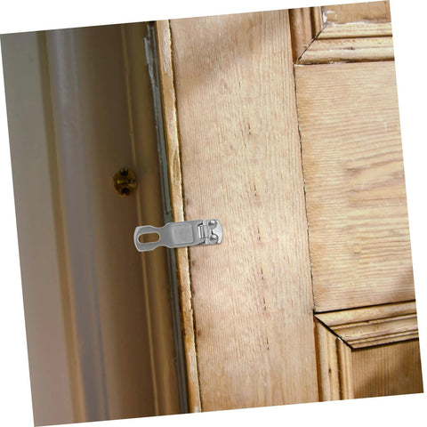 Installed stainless steel boat latch with rotating mechanism on a wooden door.