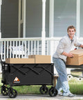 Man loading boxes into a Beast Of A Heavy Duty Collapsible Wagon Cart With Folding Wheels For Grocery Camping And Garden Use, 360 Degree Front Wheels, Ergonomic Handle, Ultra Compact Design, 200L Capacity