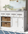 White cabinet with wicker baskets and four drawers, adorned with gold-tone knobs, in a coastal-themed room.
