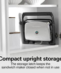 Hamilton Beach Panini Press And Sandwich Maker With Electric Indoor Grill Nonstick Plates, stored upright with latch.