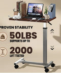 Heavy Duty Pneumatic Overbed Bedside Table With No Sweat Height Adjustment For Home Recovery Or Healthcare Use Non Tilt Surface Durable Walnut Cart with laptop and books.