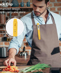Man in kitchen wearing apron with Digital Food Thermometer With Automatic Calibration clipped to pocket, chopping vegetables.