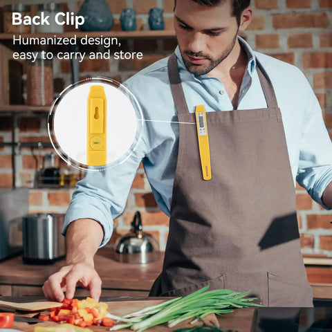 Man in kitchen wearing apron with Digital Food Thermometer With Automatic Calibration clipped to pocket, chopping vegetables.