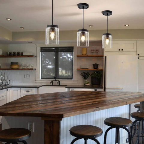 Industrial Mini Pendant Light Set With Bubble Seeded Glass Hanging Light Fixture For Kitchen Island Over Sink And Dining Room, Black Finish, 3-Pack Bundle illuminating a kitchen island.