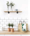 Half Inch Industrial Black Iron Pipe Shelf Brackets For Rustic Wall Mounted DIY Shelving, Hanging Brackets For Floating Shelves, 6 Inch Steel Pipe Support For Dope Modern Home Decor on a kitchen wall with plants and decor.