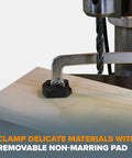 Auto Adjust 6 Inch Drill Press Clamp For Woodworking And Metalworking holding wood piece with drill press, non-marring pad visible.