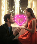 Couple with Pink Heart Neon Sign With Battery Or USB Power For A Romantic Mood And Cozy Vibes LED Heart Lights Great For Valentines Day Decor Gift For Wife Proposal Anniversary Mothers Day Or Bedroom And Living Room Table Wall Decor