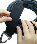 Hands using Extension Cord Holder Organizer 4 Pack Large 16 Inch Heavy Duty Storage Straps with Triangle Buckle for cable management.