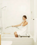 Person using 30 Inch Crescent Curved Shower Grab Bar Built Tough In Polished 304 Stainless Steel One Piece Welded Cap 250 Pound Weight Capacity Includes Mounting Screws For Easy Install in a white bathroom.