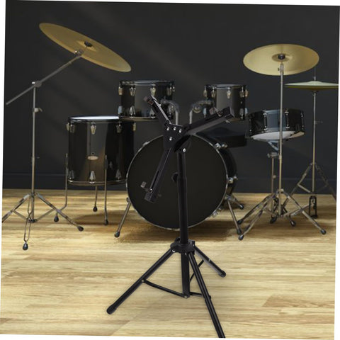 Slick Black Tripod Drum Stand With Heavy Duty Snare Rack And Practice Pad Holder Featuring Adjustable Heights, in front of a drum set.