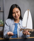Ocean Beauty Yacht Wooden Model Kit For Adults A 3D Puzzle With Paper Sails And Stand Display Ready Mechanical Sailboat Craft For Brain Teaser Building And Shelf Showpiece, adult woman holding wooden sailboat model with white paper sails