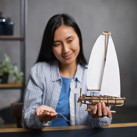 Ocean Beauty Yacht Wooden Model Kit For Adults A 3D Puzzle With Paper Sails And Stand Display Ready Mechanical Sailboat Craft For Brain Teaser Building And Shelf Showpiece, adult woman holding wooden sailboat model with white paper sails