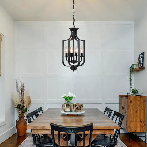 Dining room featuring a 10.63 Inch Black Farmhouse Chandelier With Four Lights Modern Industrial Lantern Pendant Light Fixture For Dining Room Kitchen Foyer Or Hallway Rustic Metal Cage Adjustable E12 Base For A Cozy Home Vibe, above a wooden table with black chairs.