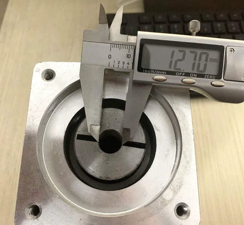 Front view of 20:1 planetary gearbox head with 1/2-inch input shaft; caliper reads 12.70 mm.