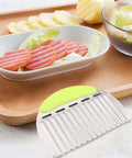 Crinkle potato cutter with green handle and curved metal blade