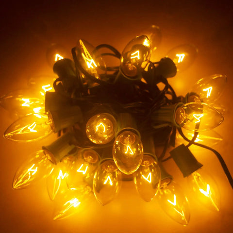 Bundle of Clear C9 Christmas String Lights 50Ft On Green Wire With 54 Bulbs, glowing warmly indoors, vintage holiday decor.