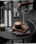 Party-Ready Hot Beverage Dispenser With Pump, 1.9L Insulated Stainless Steel Carafe, on coffee table with cups