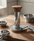Straight Up 58mm Espresso Tamper For Dead On Pulls Daily Brushed Stainless Steel Coffee Press with wood grip on a wooden surface.