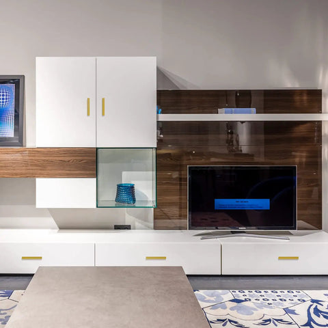 Modern living room with white and wood cabinets, featuring gold cabinet pulls, TV stand, and decorative items on shelving.