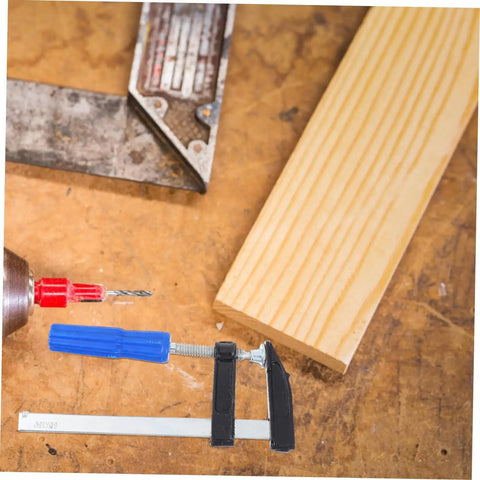 Workbench with drill, wood plank, and 4Pcs Woodworking Clamps Set For Quick Fixing And Boss Grip Heavy Duty Carpentry Clips.