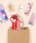 Brown Kraft Gift Bags With Handles 5.25x3.75x8 Inches 20 Pack filled with cosmetics, glasses, and a gift, flat lay view.