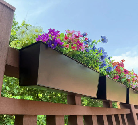 Set Of Four Heavy Duty Metal Railing Planters, 16 Inch Rectangular Window Boxes with colorful flowers on a wooden railing.