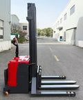 No Sweat Manual Hydraulic Pallet Stacker And Warehouse Lifter Cart with heavy duty swivel casters viewed from the side on a workshop floor.