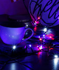 Patriotic 200 LED 66Ft Fairy String Lights With 8 Lighting Modes illuminating a cup in red, white, and blue.