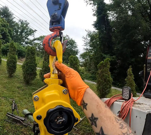 Hand holding Two Pack Viking Manual Lever Chain Hoist 1.5 Ton Lift 20 Ft Reach 3000 Lbs Capacity with heavy duty hooks.