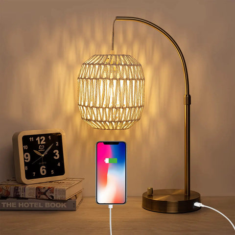 Tall Industrial Gold Rattan Bedside Table Lamp With USB Charge Port glowing beside clock and books