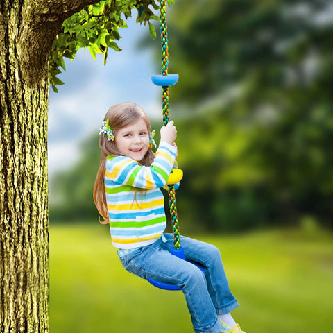 Child playing on a kid friendly outdoor swing set with disc seat climbing rope and platform heavy duty tree swing kit in a backyard.