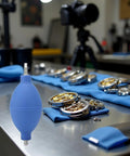 Blue Rubber Soft Cleaning Tool for Wristwatch Parts on the Go, Dust Air Blower Pump on workbench with watch components